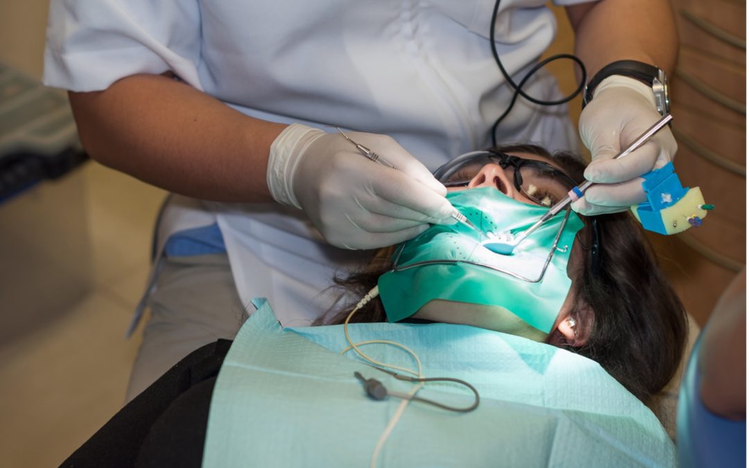 dentist working on a persons mouth, root canal treatment