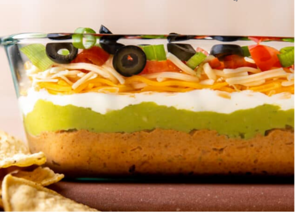 A picture containing a bowl of seven-layered dip