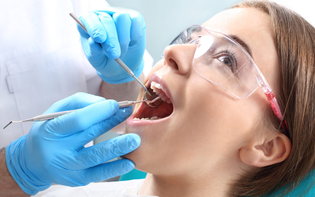 Root Canal Health Benefits: Why Endodontic Care Is Essential for Your Overall Health, Woman at the dentist's chair during a dental procedure